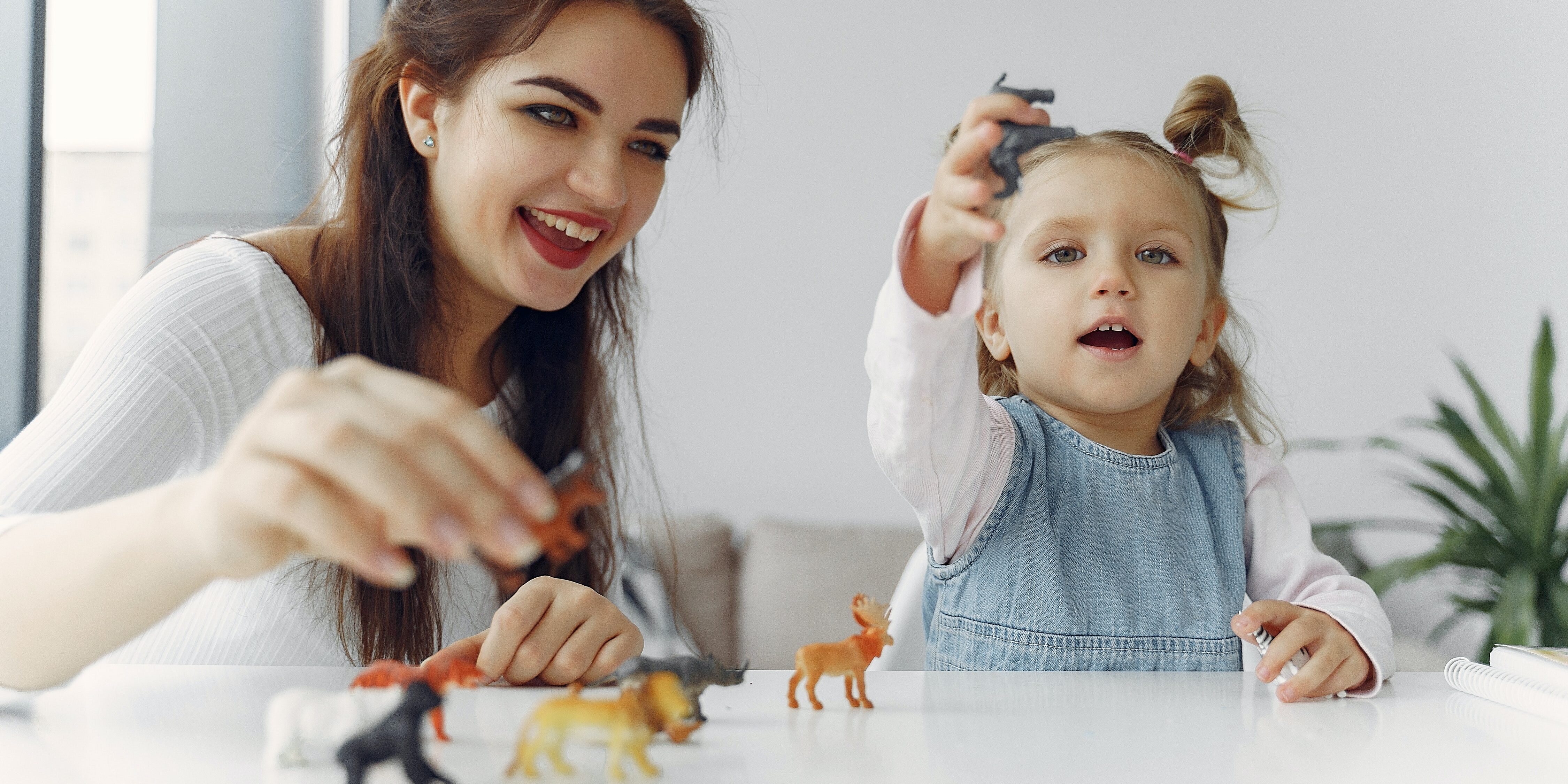 little-girl-playing-animal-figures-with-her-mother-3985019